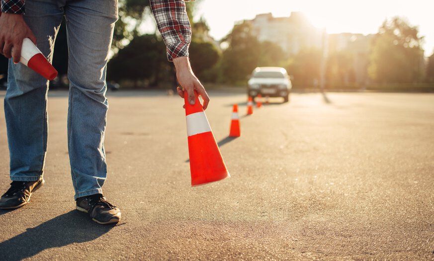 Mann stellt Verkehrskegel auf die Straße