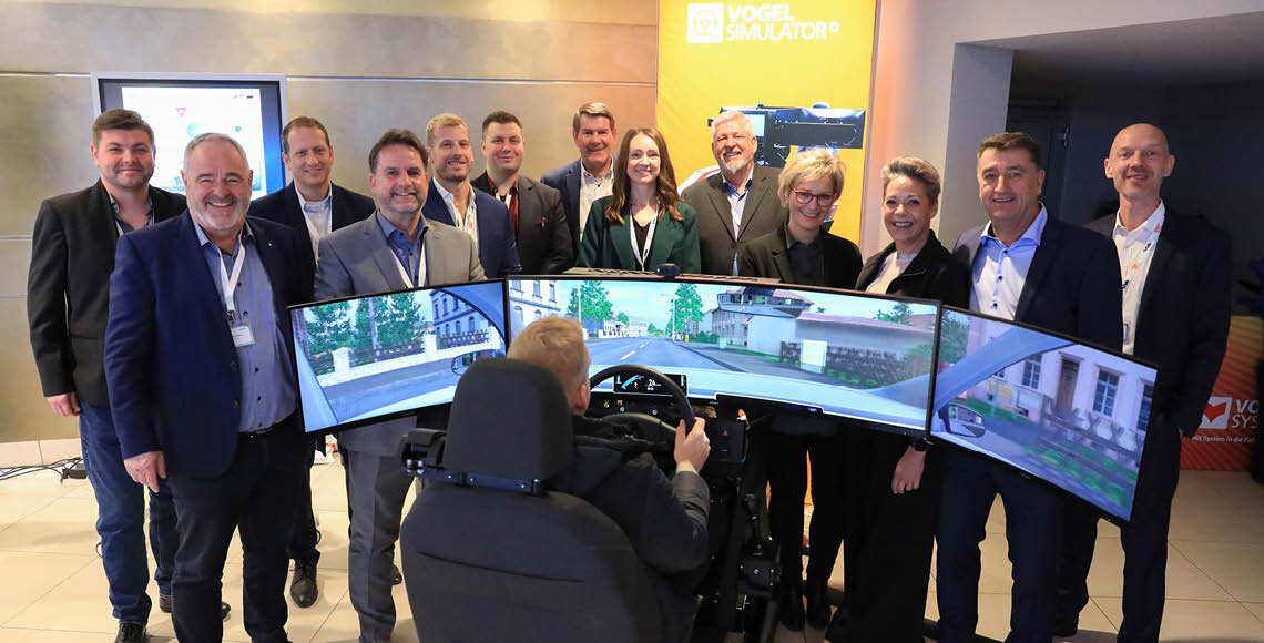 Das Vogel System Messe Team steht um den Simulator