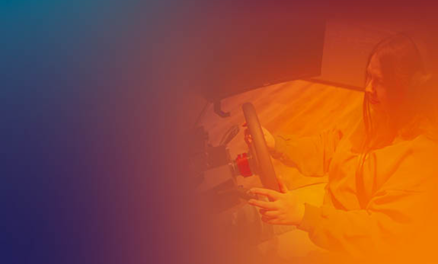 Teenagerin an Simulator Fahrschülerin fährt an Simulator