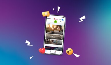 Smartphone mit dynamischer Fahren Lernen Oberfläche vor farbigem Hintergrund. Emojis, Hashtags und Icons symbolisieren Interaktion, Social Features und Nutzeraktivität.