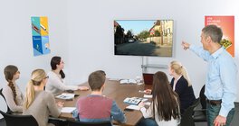 Drivers Cam im Fahrschulunterricht Fahrschüler*innen und Fahrlehrer betrachten Fernseher mit Drivers Cam Lektion
